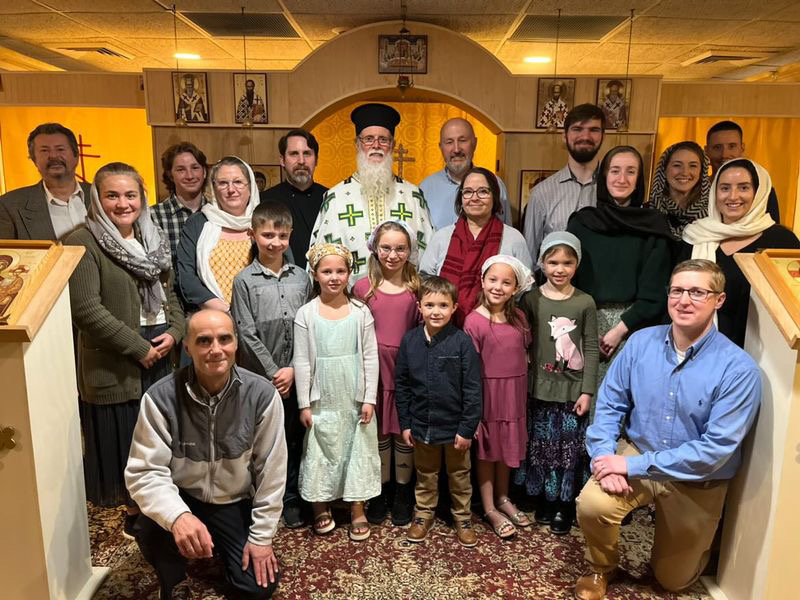 The parish gathered before the iconostasis with the bishop in festal vestments at the centre, clergy, families and children together